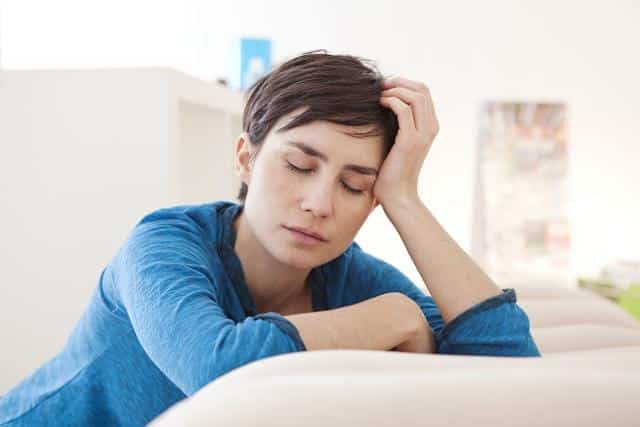 femme épuisée sur son canapé