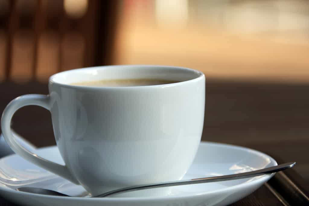 Gros plan sur une tasse de café noir fumant