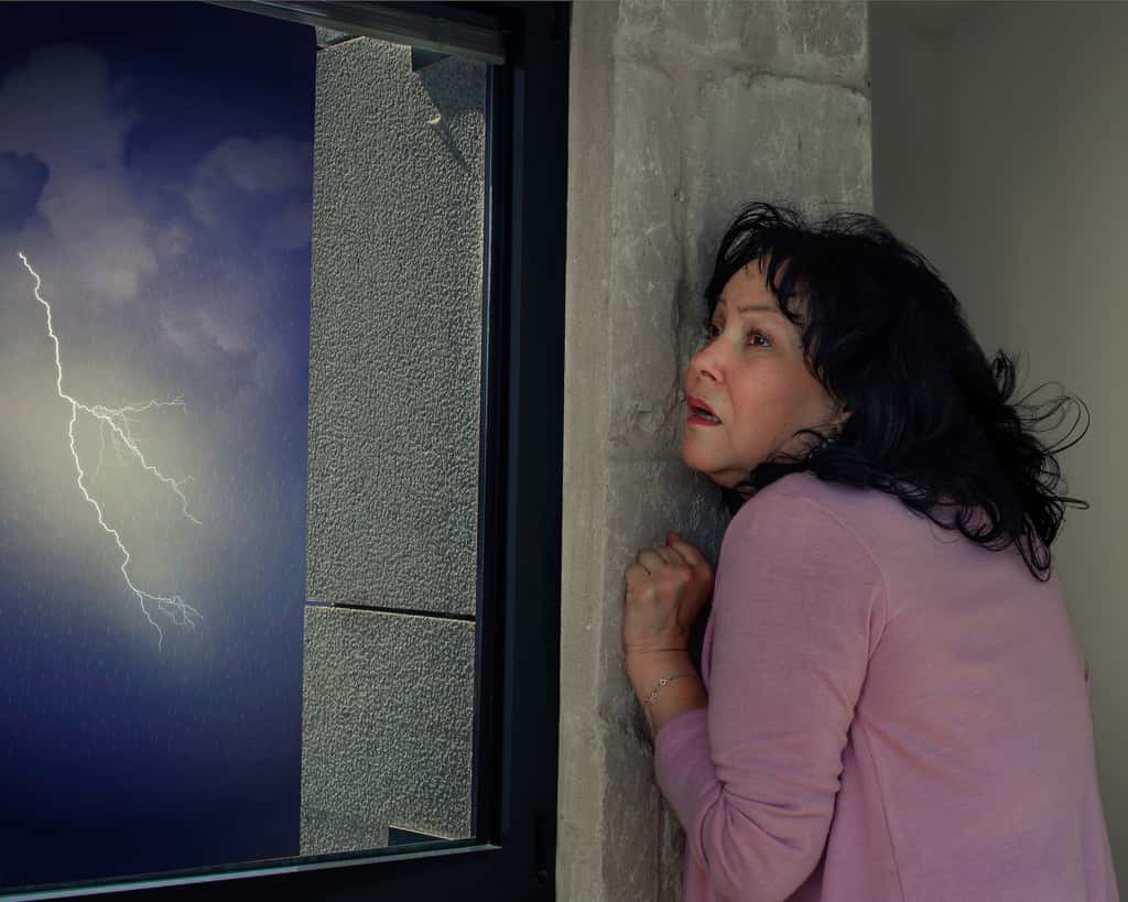 Personne regardant un orage avec inquiétude