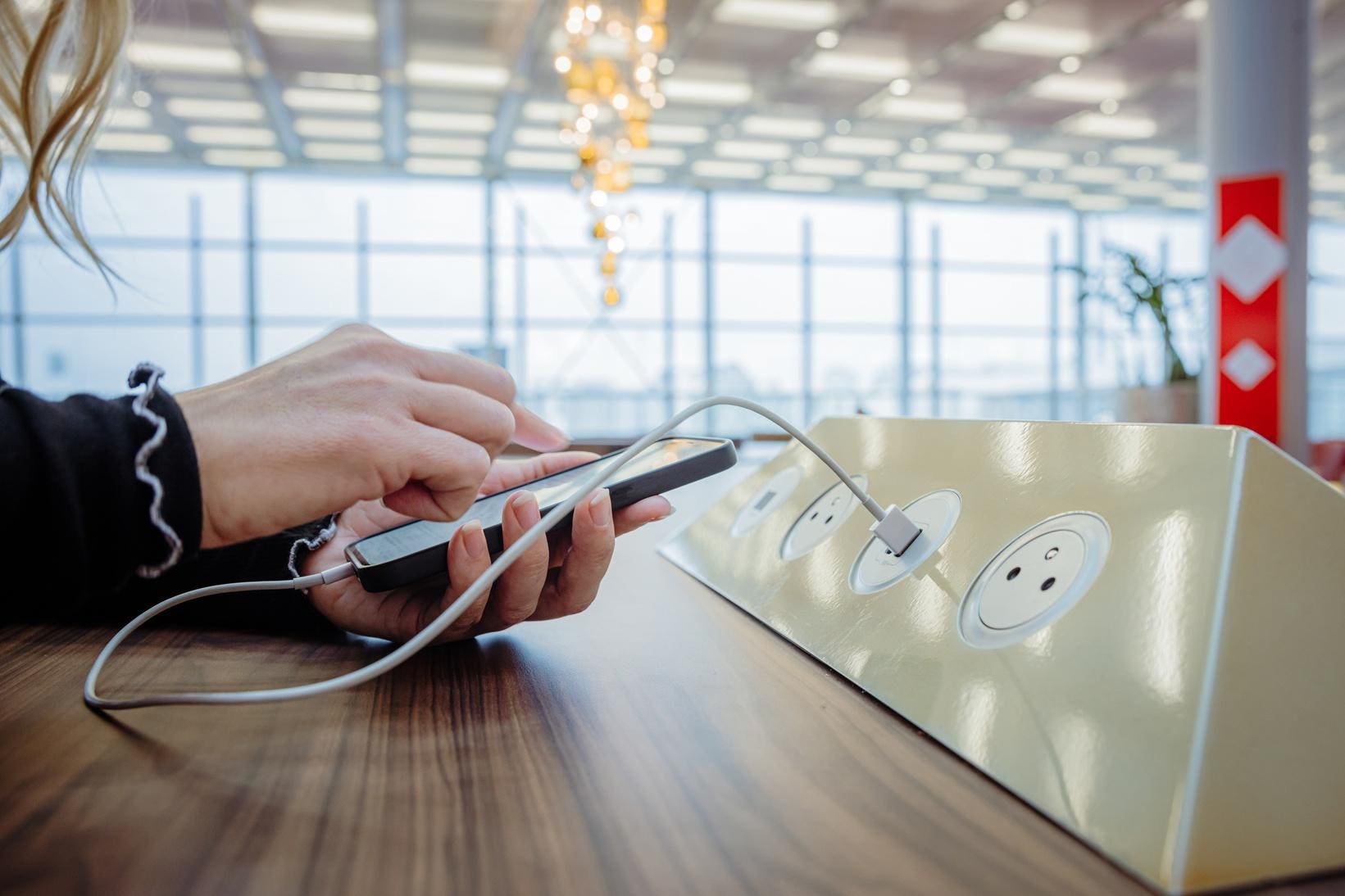 Personne rechargeant son téléphone dans un aéroport