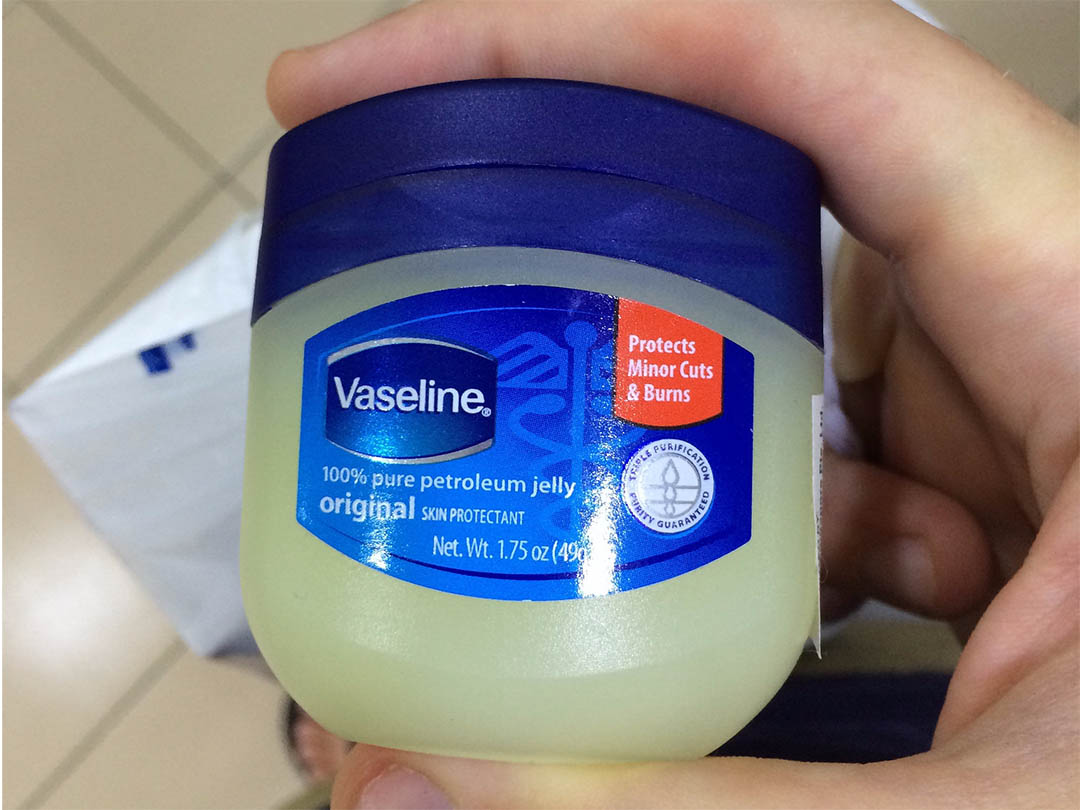 Pot de vaseline posé près de fleurs séchées