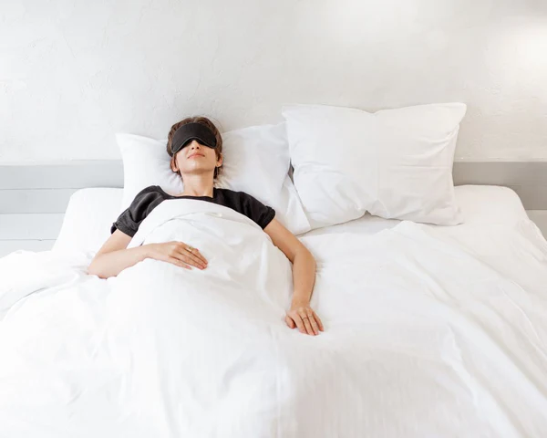 Dormeur sur le dos, avec oreillers positionnés pour un bon soutien