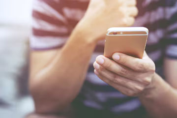 Homme utilisant son smartphone de manière furtive