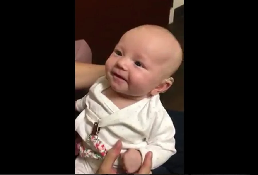 Sourire touchant de la petite fille malentendante découvrant la voix de sa mère