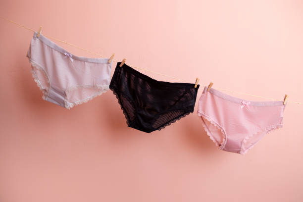 Deux femmes riant devant des sous-vêtements colorés étendus