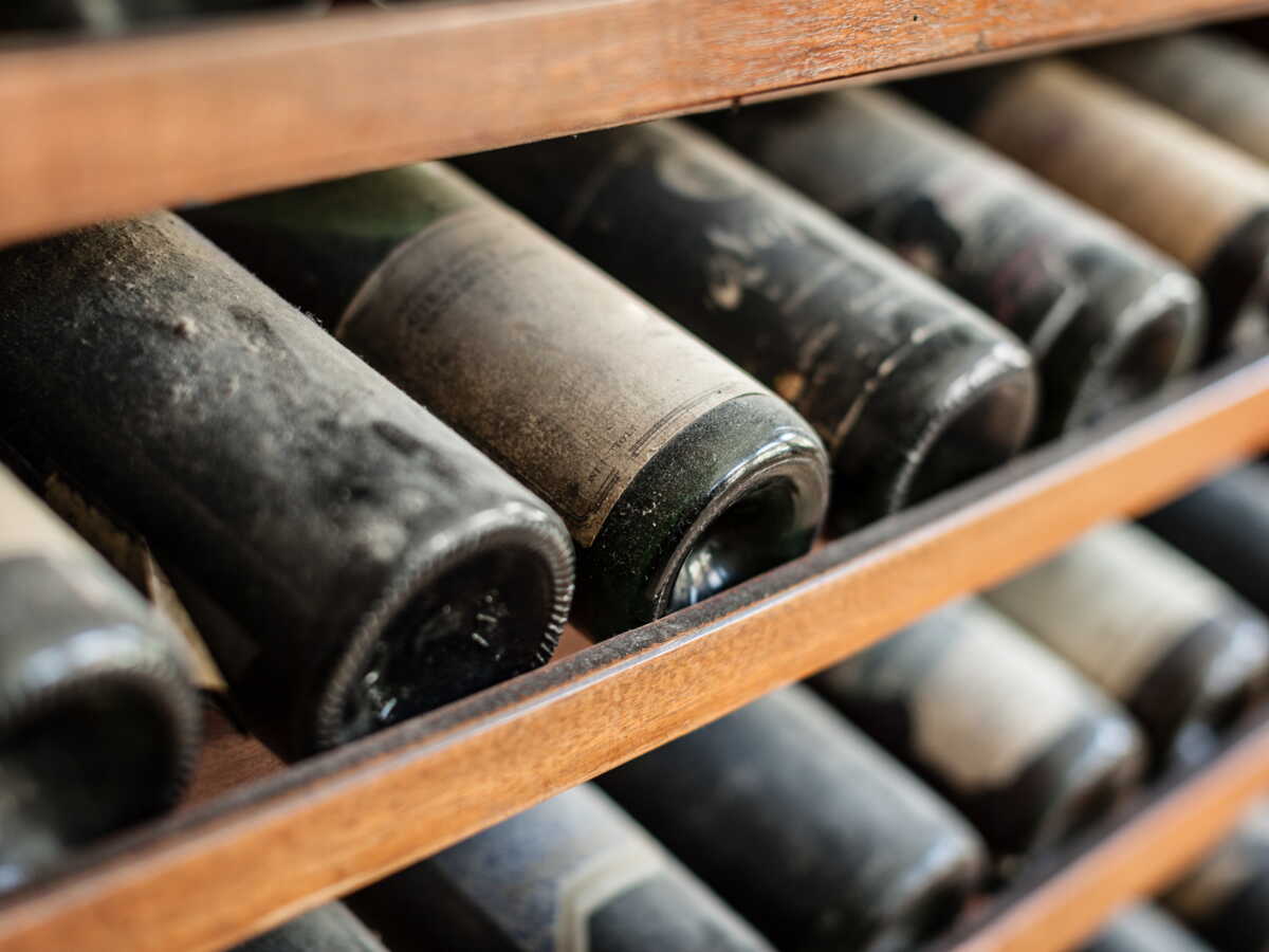 Main tenant une bouteille de vin par le fond concave