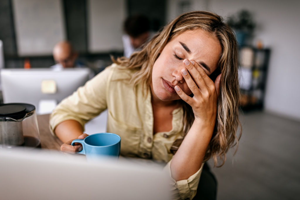 Femme fatiguée se frottant les yeux au travail
