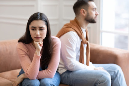 Couple assis dos à dos, regard perdu dans le vide