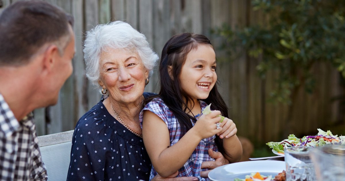 Couple de seniors partageant un repas équilibré et joyeux en terrasse