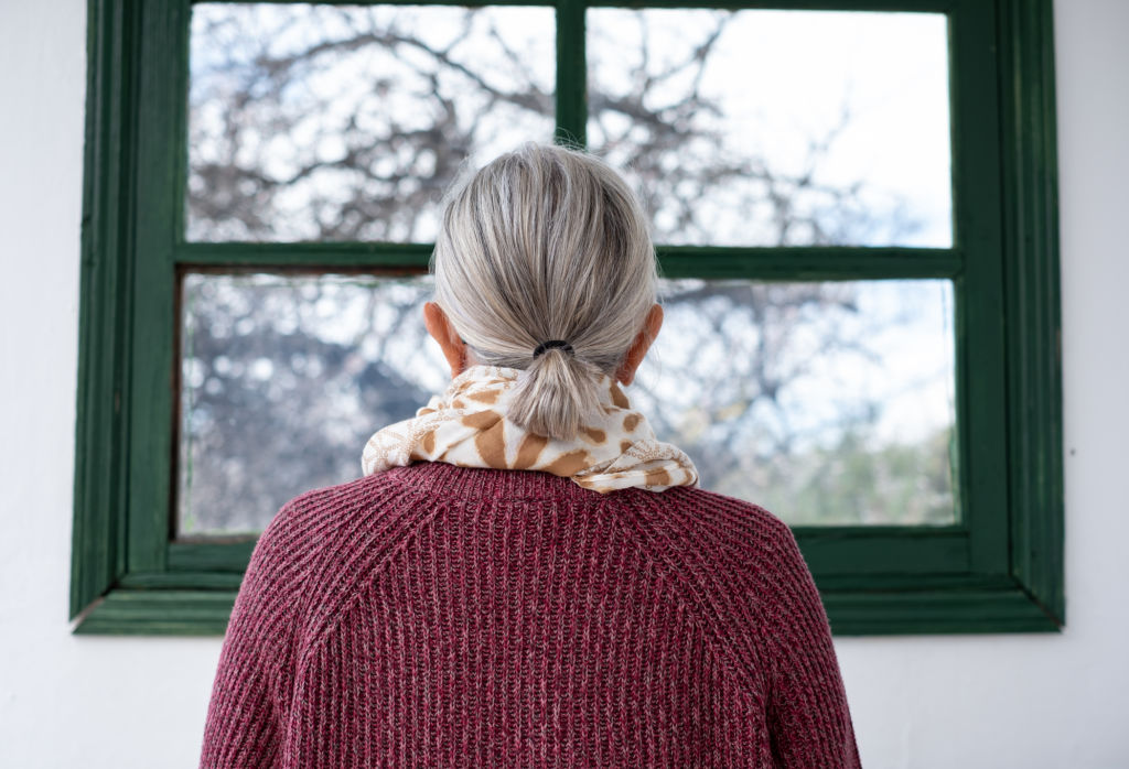 Femme âgée regardant par la fenêtre