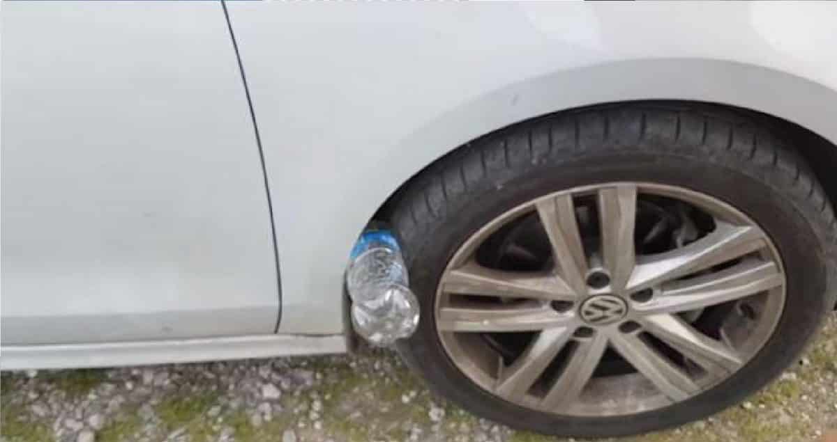 Personne réalisant un contrôle visuel autour de sa voiture