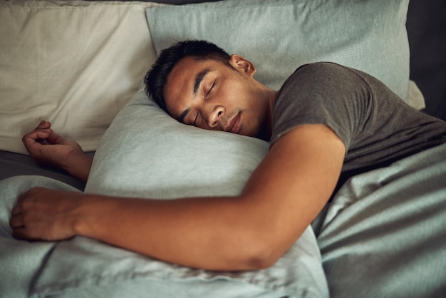 Jeune homme dormant paisiblement dans son lit