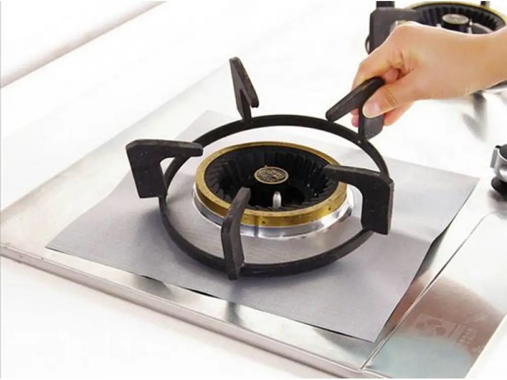 Grilles de cuisinière sales posées à côté d'éponges et de produits de nettoyage