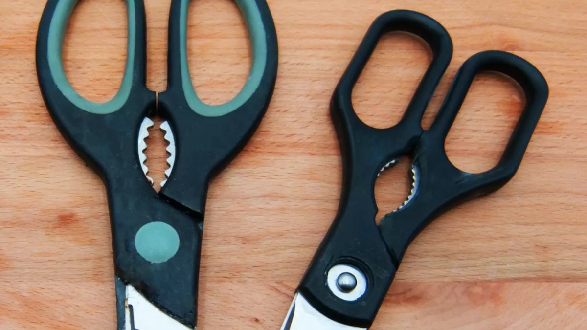 Ciseaux de cuisine posés sur un plan de travail en bois