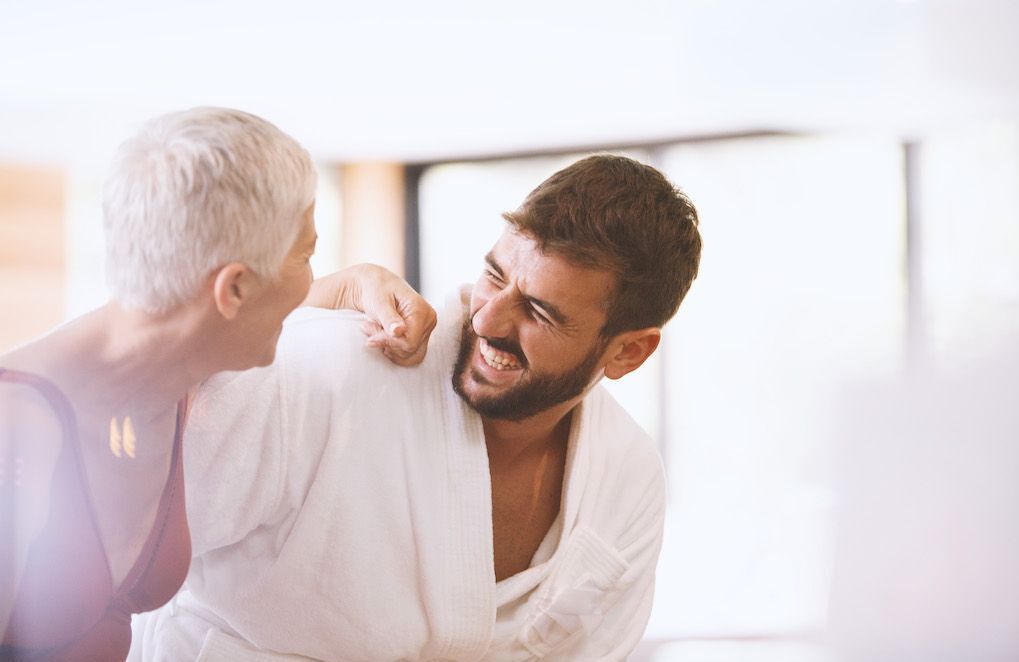 Femme souriante et complice avec un homme plus jeune, discutant dans un cadre chaleureux