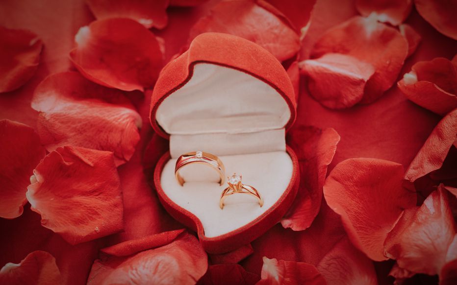 L'homme, désormais élégant, est à genoux et tend un écrin à la jeune femme ébahie