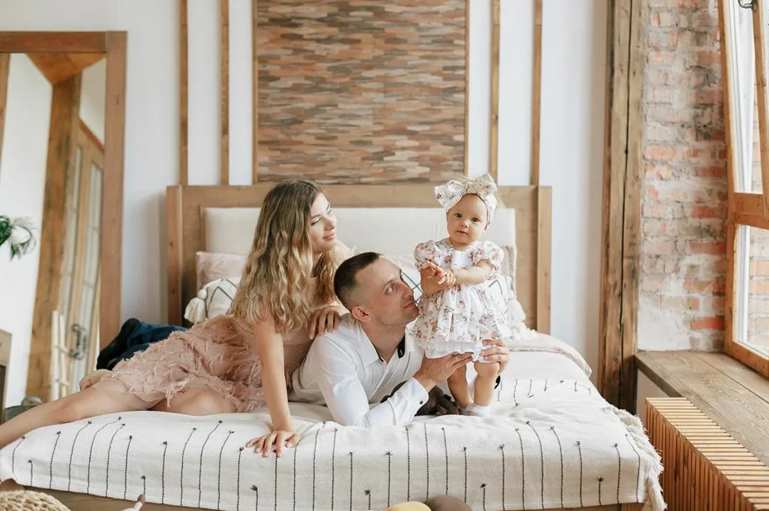 Mains d'un adulte tenant délicatement les petits pieds d'un bébé.