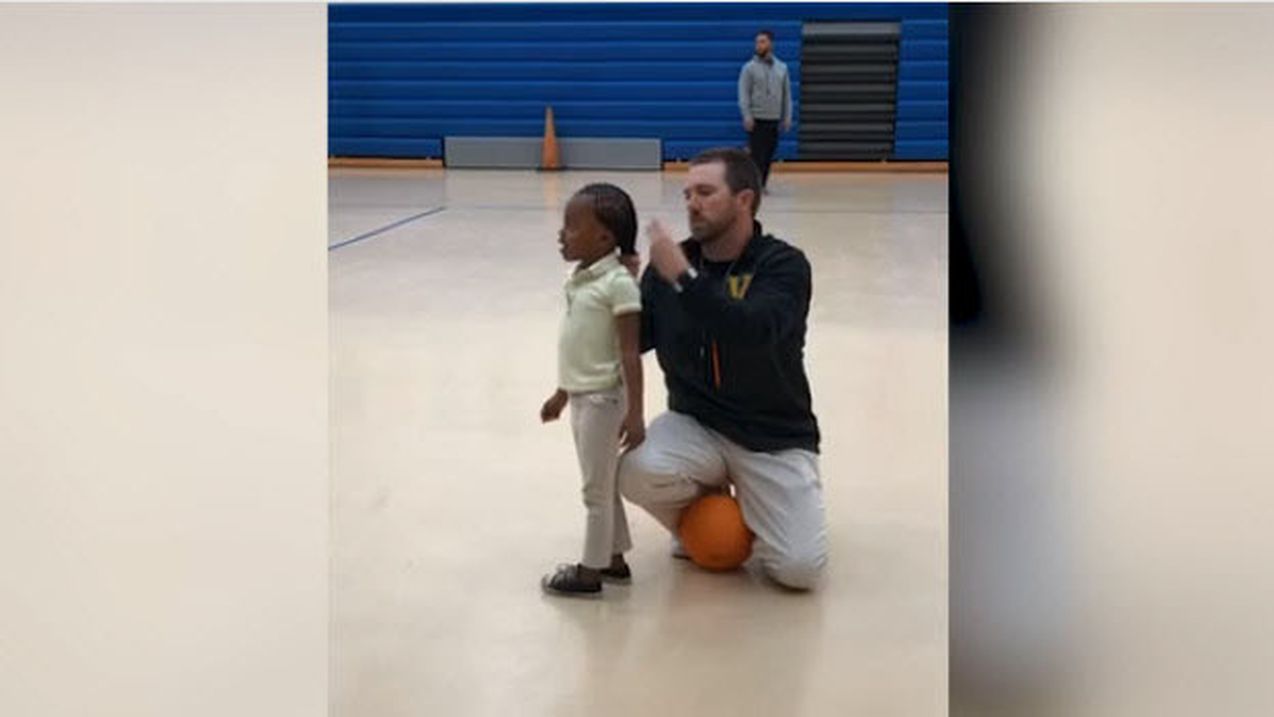 Entraîneur attachant les cheveux d'une petite joueuse de basket