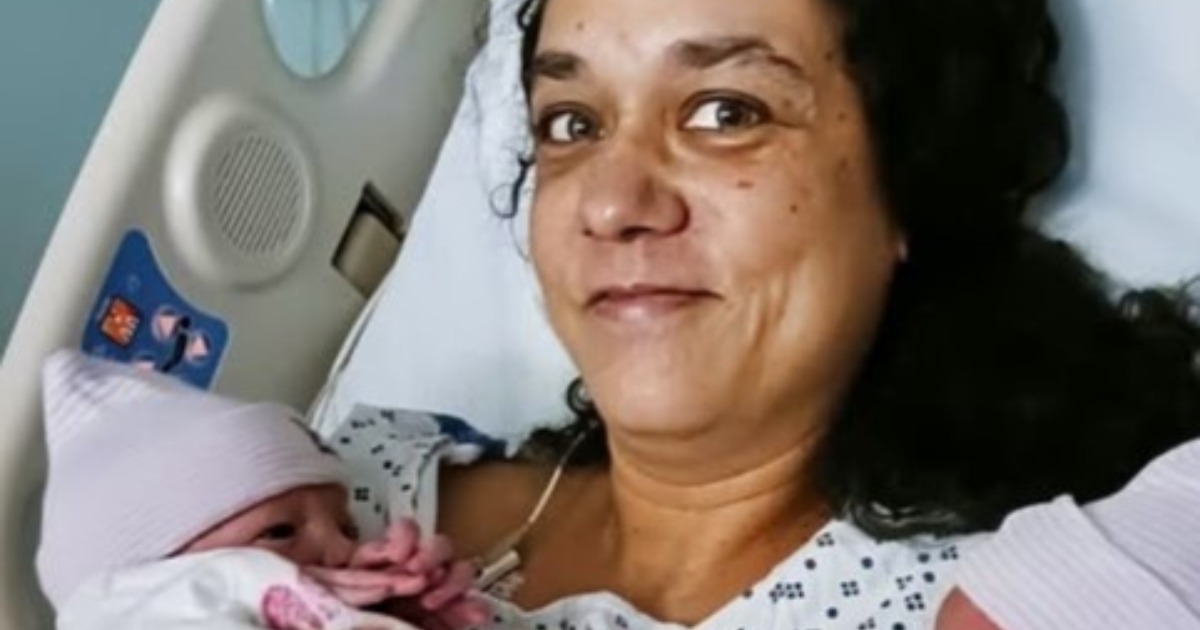 Une femme d'âge mûr, Claire, regarde une échographie avec une expression mélangée de surprise et d'émotion.