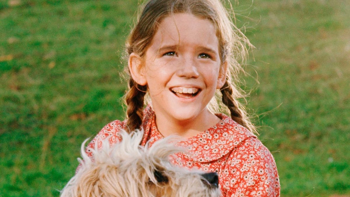 Jeune Melissa Gilbert dans le rôle de Laura Ingalls, souriante dans un champ
