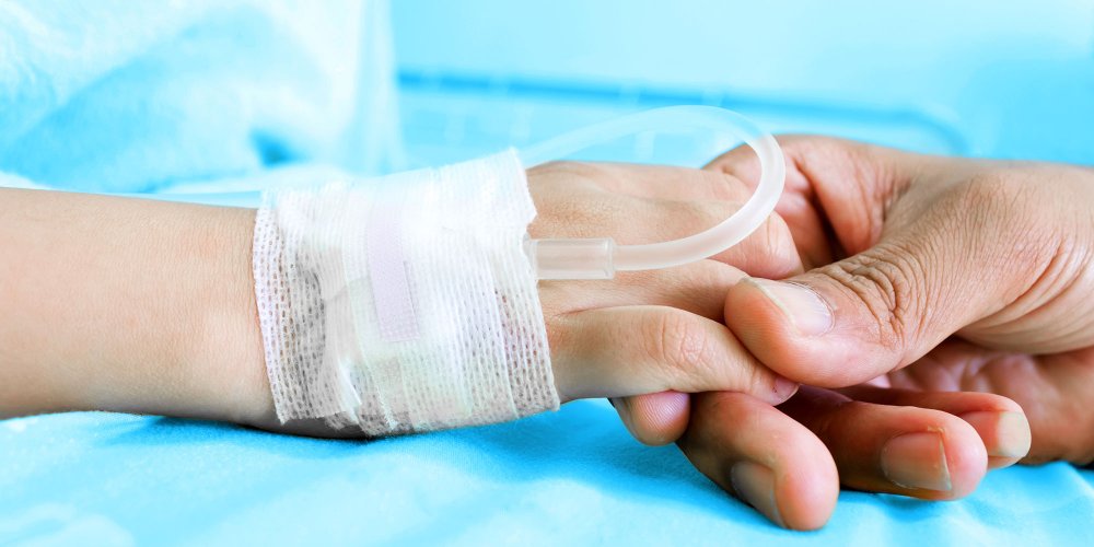 Main d'un parent tenant la main d'un enfant à l'hôpital